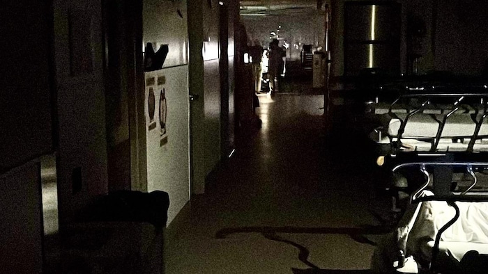 Le corridor d'un hôpital est dans la pénombre.