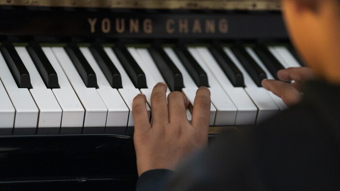 Un enfant joue du piano.