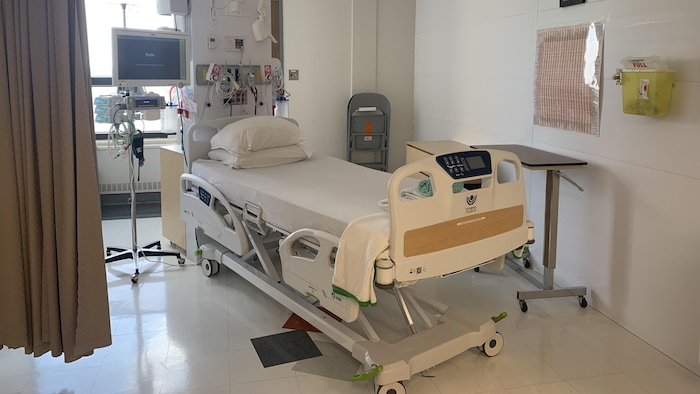 Un lit d'hôpital muni de plusieurs appareils.