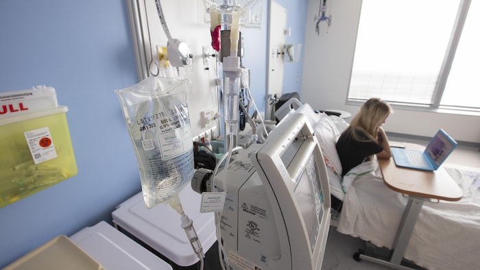 Une femme dans un lit d'hôpital.