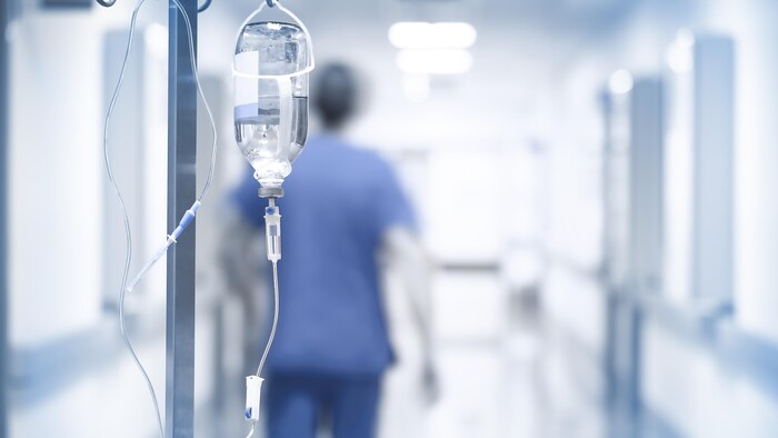 Un médecin marche dans le corridor d'un hôpital.