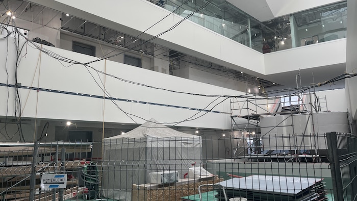 Espace sous construction avec grillages et équipements.