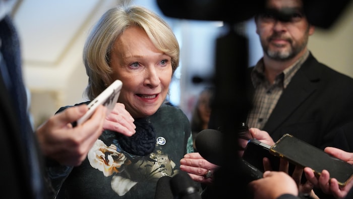 Une ministre dans un corridor.