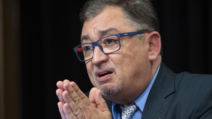 Le Dr Horacio Arruda a les mains jointes, comme pour prier.