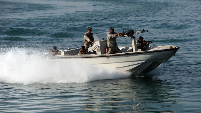 Des soldats dans un bateau avec une mitraillette.