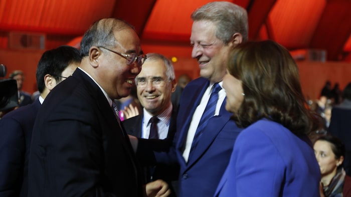 Trois personnes se félicitent de l'adoption de l'Accord de Paris.