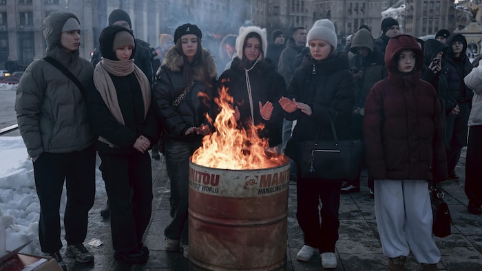 Des adolescents se réchauffent près d'un feu improvisé lors d'un programme artistique commémoratif à Kiev.