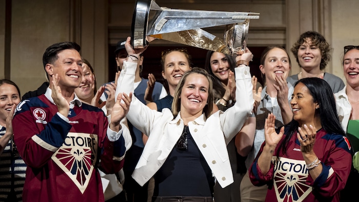 La capitaine de la Victoire, Marie-Philip Poulin, soulève la coupe entourée de ses coéquipières, de la mairesse de Montréal, Soraya Martinez Ferrada, et du maire de Laval, Stéphane Boyer.