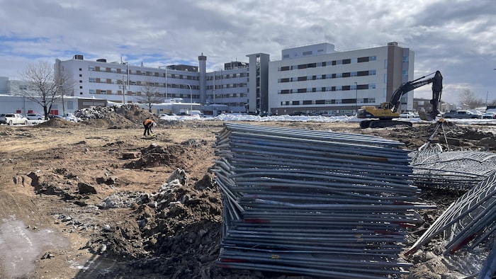 Un chantier avec en arrière-plan l'hôpital de Sept-Îles.