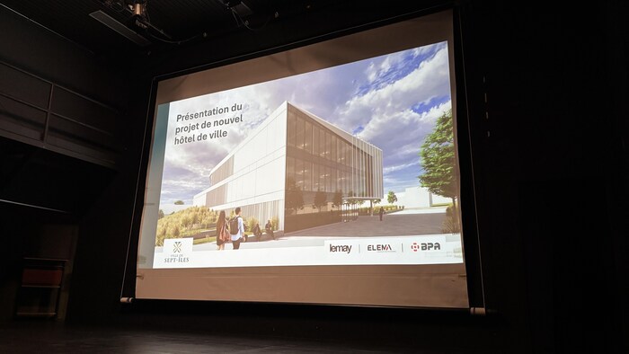 Sur une toile, une image du nouvel hôtel de ville de Sept-Îles est projetée.