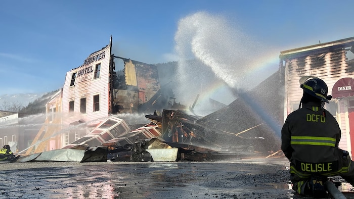 Un pompier dirige une lance d'eau vers l'hôtel Westminster détruit par un feu.