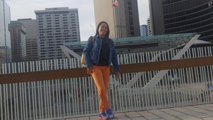 Si Nora Hayagan nakatayo habang makikita sa likod ang Toronto City Hall.