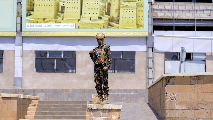 Un membre des forces de sécurité des autorités houthies monte la garde à l'aéroport international de Sanaa.