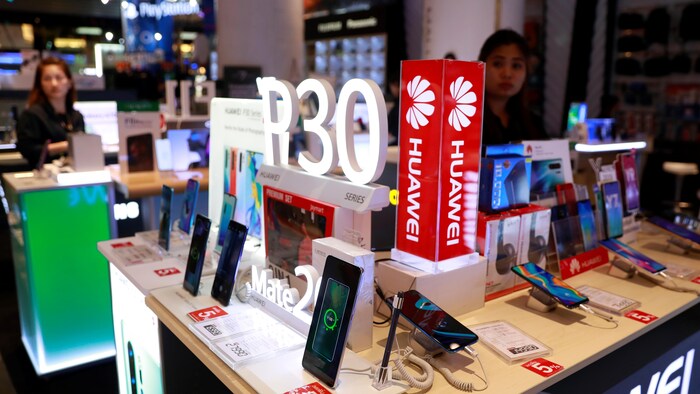 Un employé vend des téléphones intelligents Huawei P30 dans un centre commercial à Bangkok, en Thaïlande, le 22 mai 2019. 
