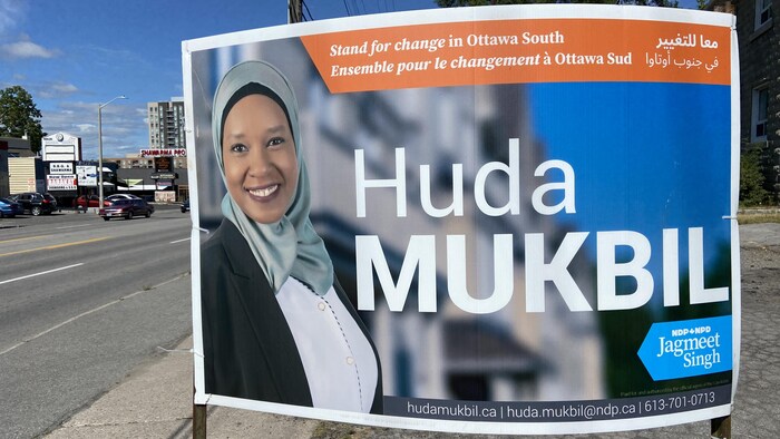 Un cartel electoral de una candidata colocado en el poste de una calle.