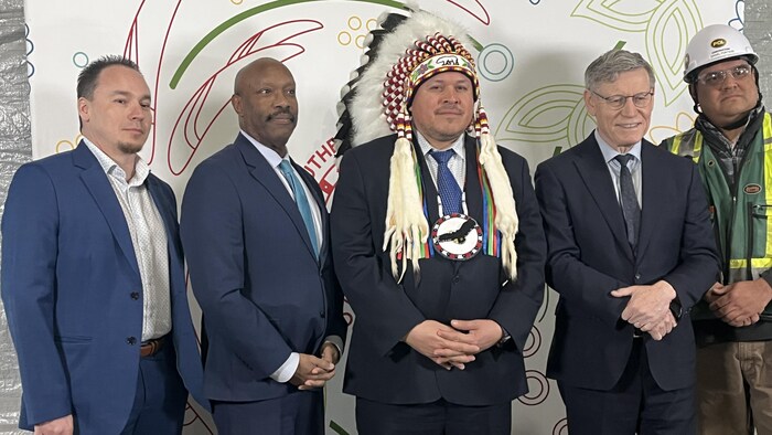 Cinq hommes posent pour être photographiés.