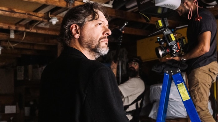Un homme vêtu de noir sur un plateau de tournage.