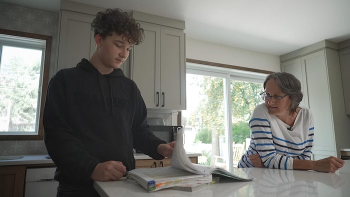 Véronique Drolet dans sa cuisine aux côtés de son fils Hugo.