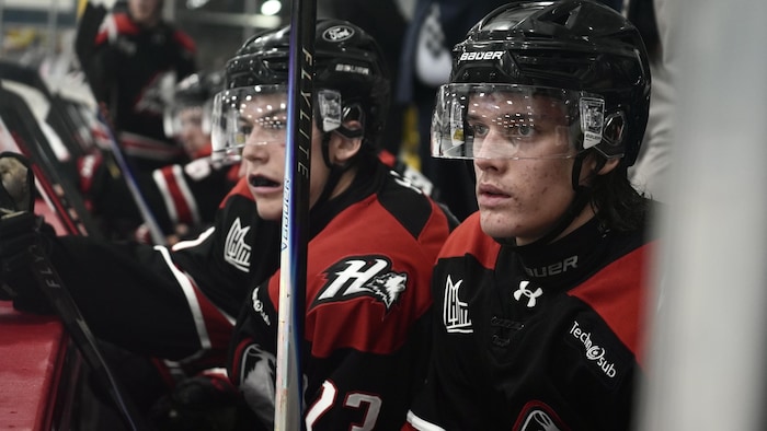 Des joeurs des Huskeis au banc des joueurs.
