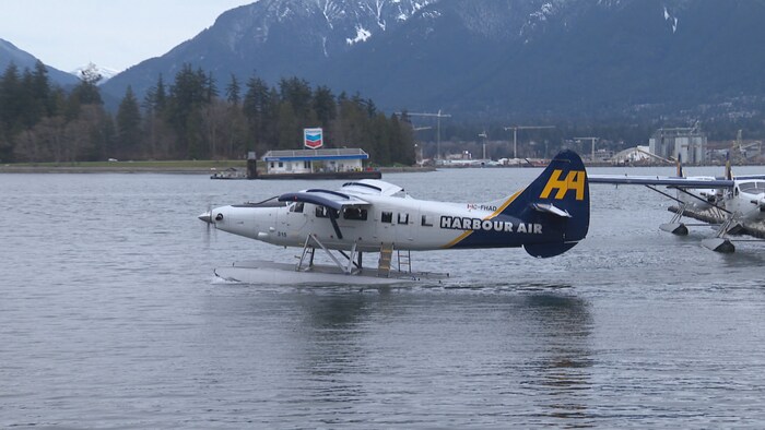 Un hydravion de profil dans l'Anse Burrard devant une station-service navale.