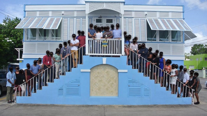 Il s'agit d'une trentaine de personnes devant des bureaux à la Barbade.