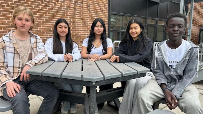 Des élèves de l'école General Wolfe assis autour d'une table. De gauche à droite, Denys Kotochihov, Shamira Salazar, Qyra Francisco, Mary Wah et Chuol Monybuny.
