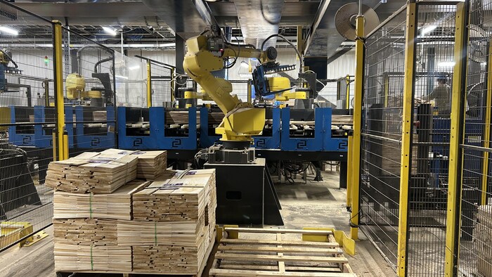 Un bras mécanique dans une usine de bois.