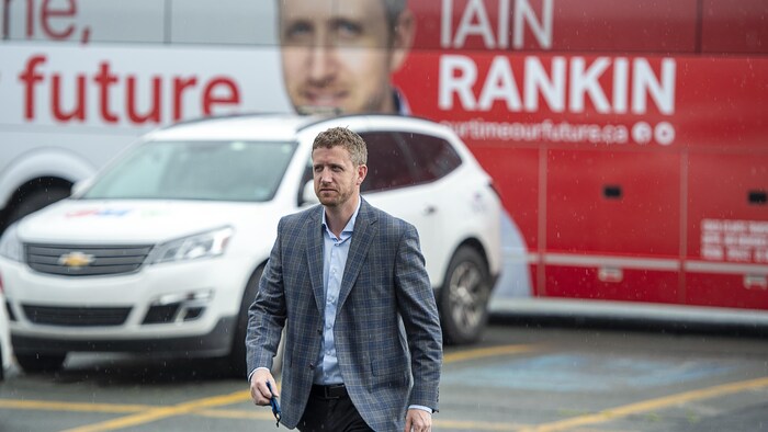 Iain Rankin marche en sortant de son autobus de campagne électorale, le 30 juillet 2021, à Halifax.