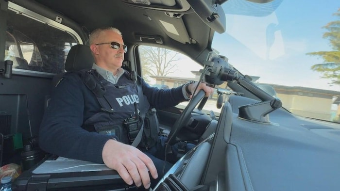L’agent Ian Smith au volant de sa voiture de travail.