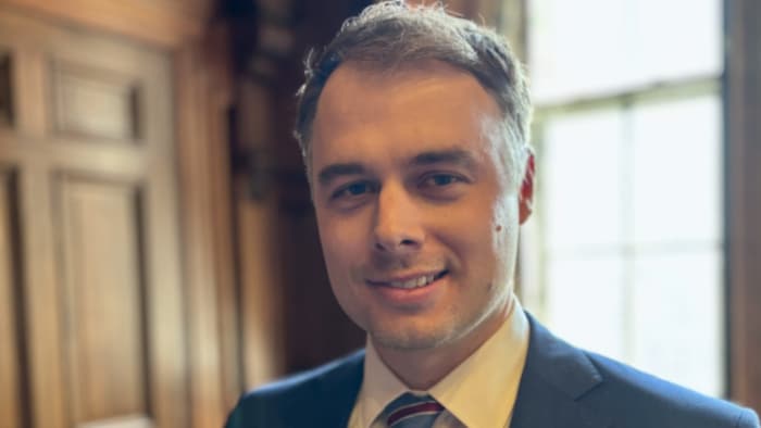 Ian Dunn airs  en avant d'une fenêtre.