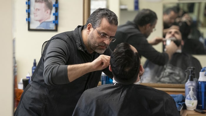 Brahim El Jaouhari taille la barbe d'un client. 