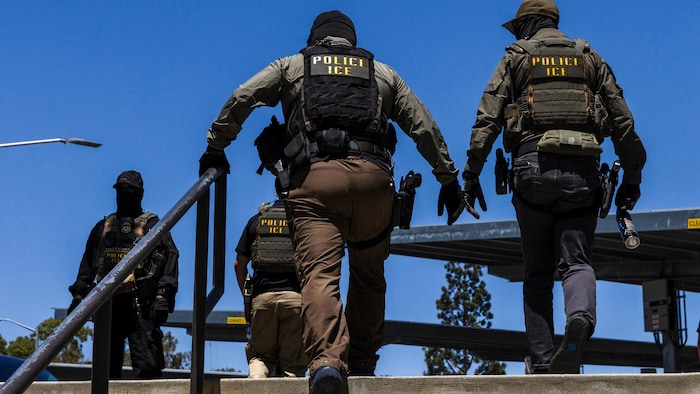 Des agents de l’Immigration and Customs Enforcement (ICE) marchent devant le Centre administratif du comté de Ventura, à Ventura, en Californie, le 27 juillet 2026.