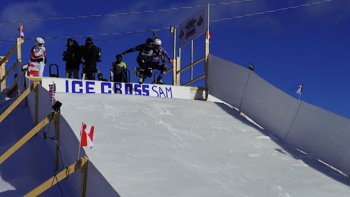 Des patineurs s'apprêtent à dévaler la pente glacée. 
