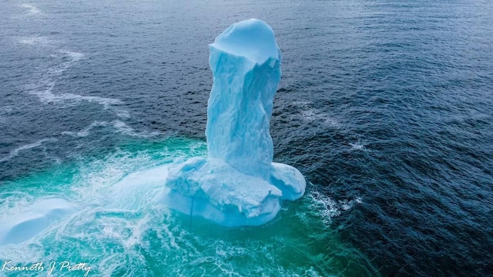 Un imposant iceberg qui ressemble à un pénis flottant sur deux testicules dérive dans l'océan.