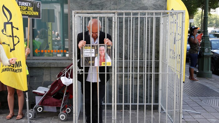 Le directeur d'Amnistie internationale en Belgique, Philippe Hensmans, se tient dans une cage devant l'ambassade turque à Bruxelles pour dénoncer la détention de sa collègue Idil Eser.