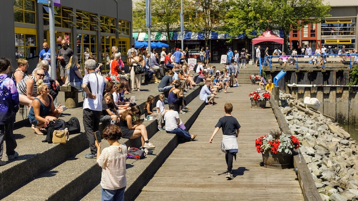 De nombreuses personnes sont assises au soleil à l'île Granville.
