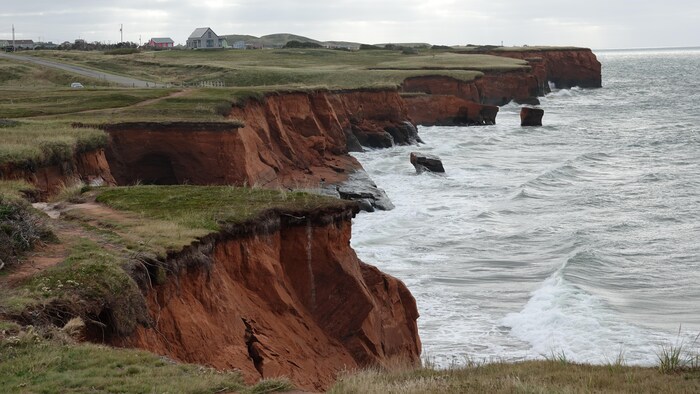 Des falaises de grès rouge sont érodées par la mer.