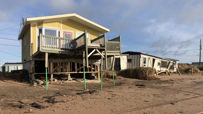 Une résidence endommagée sur une plage des Îles-de-la-Madeleine.