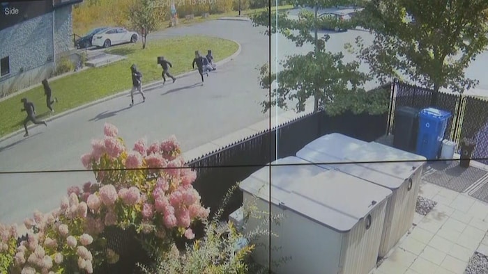 Des jeunes courent dans une rue résidentielle.