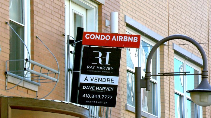 Une affiche annonçant la vente d'un condo destiné à la location Airbnb dans le quartier Saint-Roch, à Québec