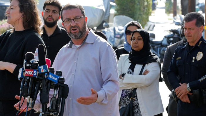 Taha Hassane parle derrière de nombreux micros de différents médias lors d'une conférence de presse dehors.