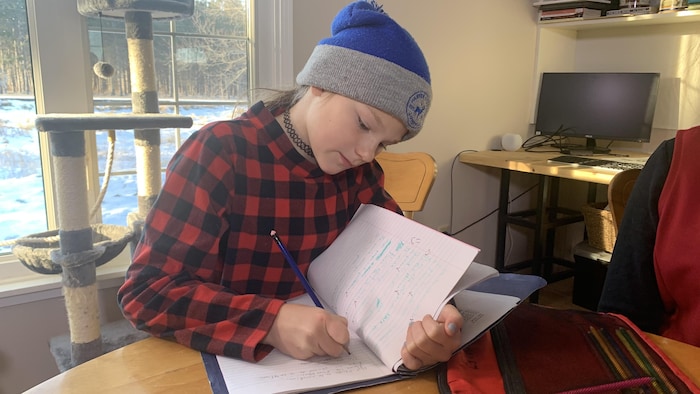 Esther Gerbrandt prend des notes dans son cahier de français.