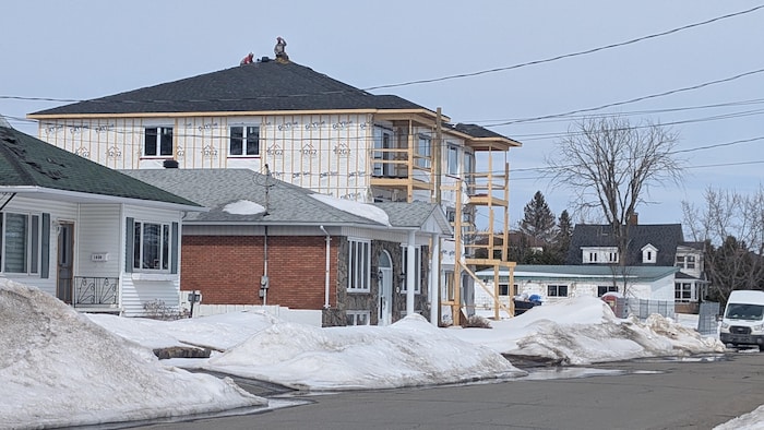 Un immeuble en construction dans un quartier résidentiel en hiver.