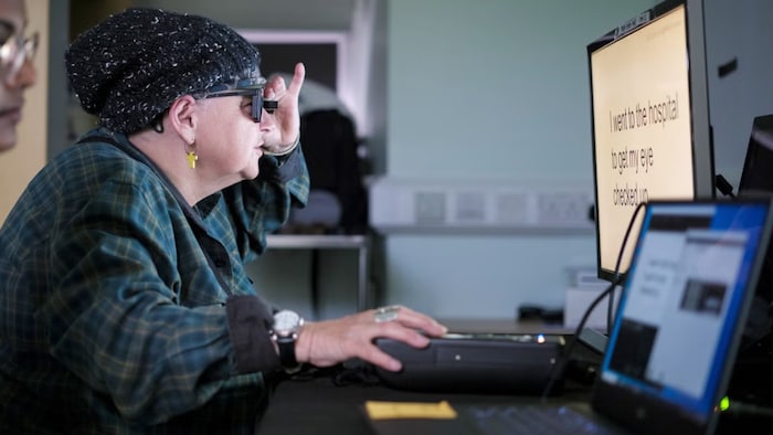 Sheila Irvine, patiente opérée des yeux, devant un écran d'ordinateur.