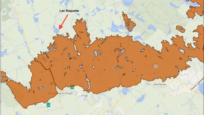 La carte montre en orange la zone dévastée par le feu de forêt de 1903. Une flèche pointe vers le lac Raquette en haut à gauche.