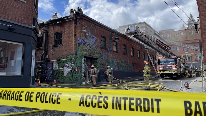 Des pompiers autour et sur la bâtisse. 