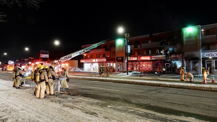 Un déploiement de pompiers dans la nuit dans un décor urbain.