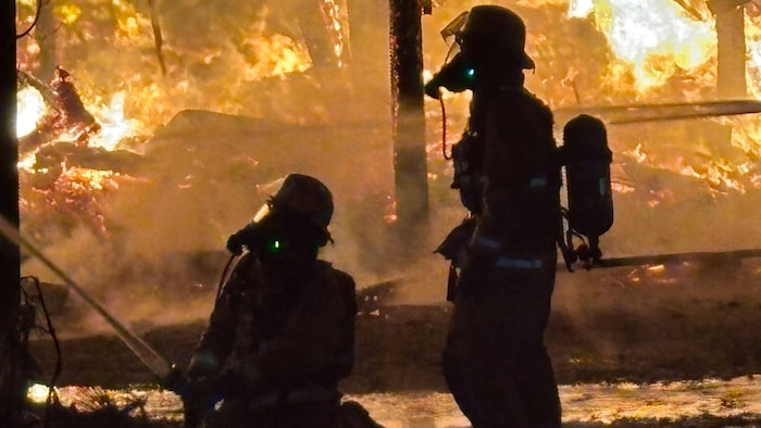 Des pompiers qui arrosent un feu.