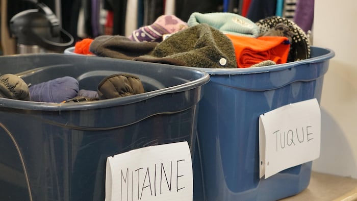 Des bacs avec des mitaines et des tuques.