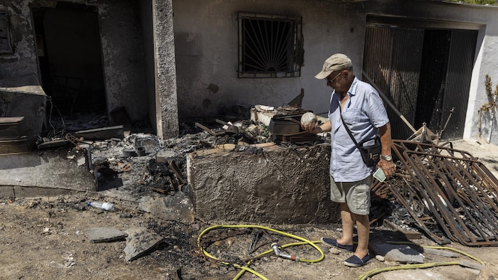Luis Cervera examine une boule de verre carbonisée près de sa maison incendiée.